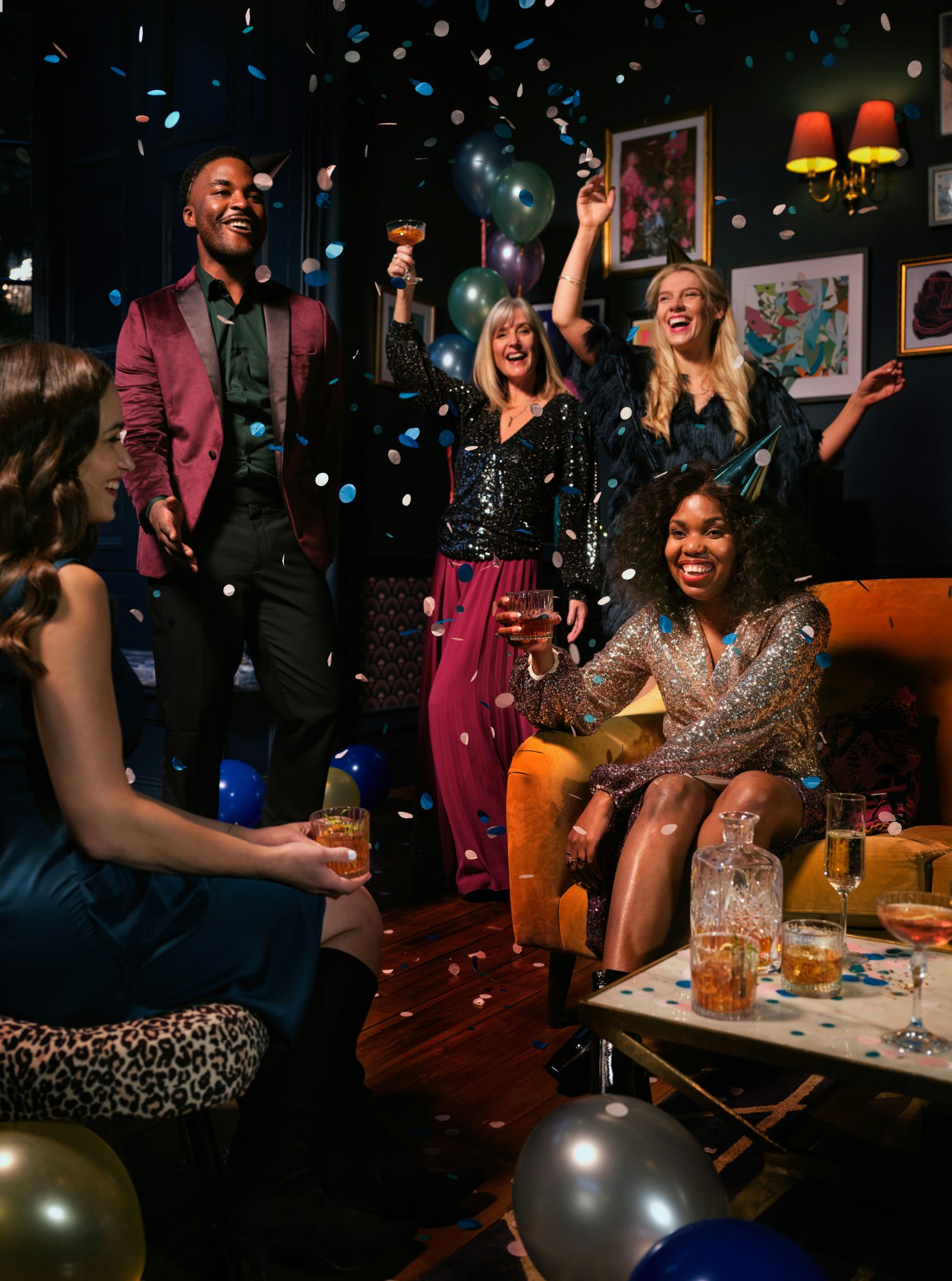 Friends drinking whisky and cocktails at a Christmas or New Years Eve party. This image is part of the OurWhisky Foundation’s Modern Face of Whisky library, designed to challenge gender bias and impro