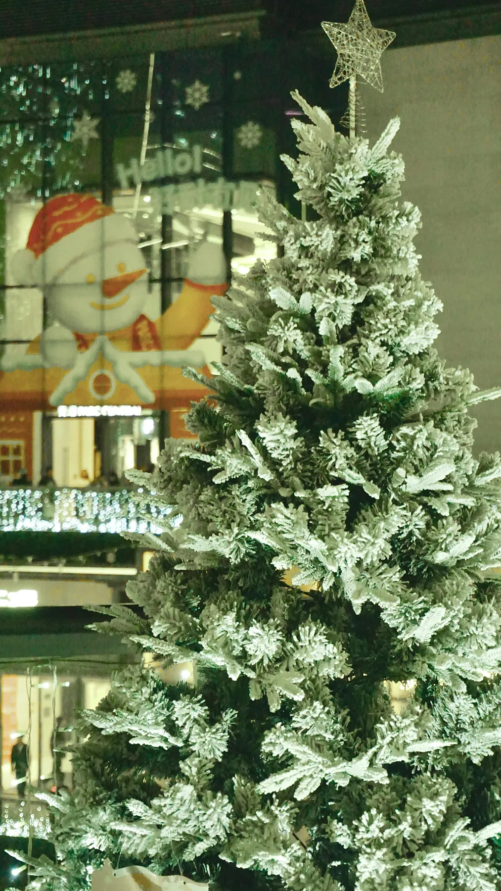 Frosted christmas tree with star topper and snowman decoration