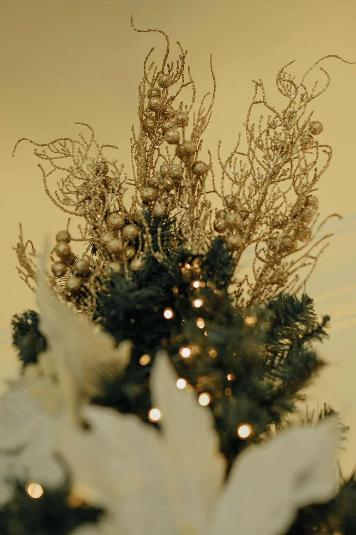 Golden Christmas tree topper with twinkling lights against a warm background.