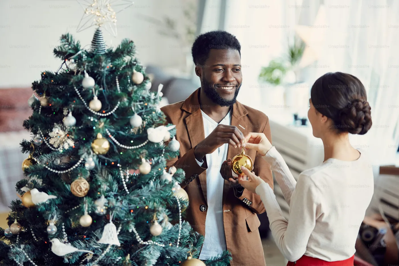 High angle portrait of smiling married couple decorating Christmas tree  together standing in elegant living room, copy space - Photo on Unsplash+