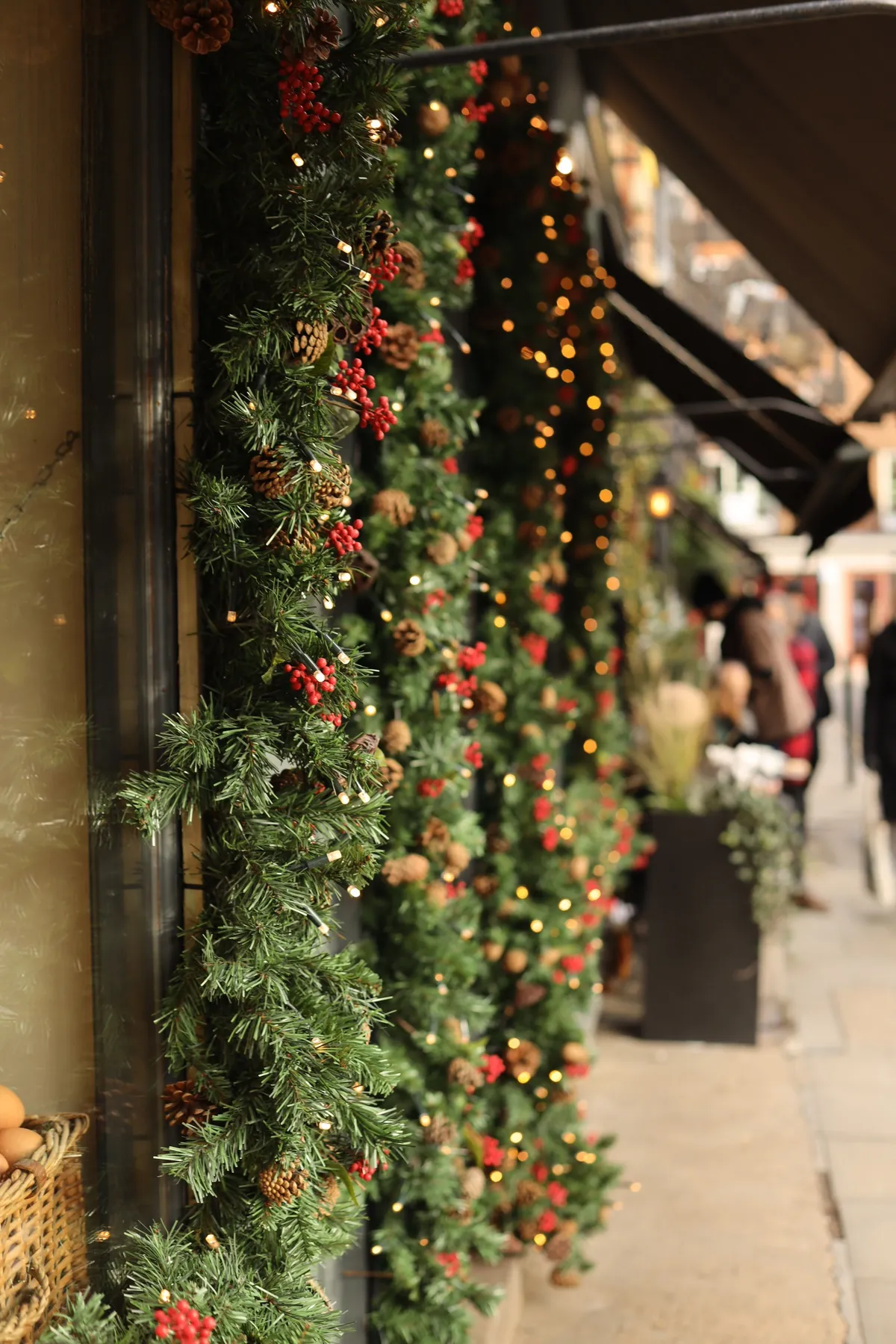 Holiday shop exterior with lush Christmas garlands and lights.