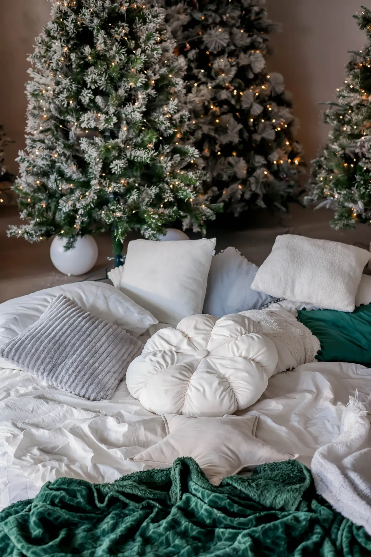 Inviting winter setting with Christmas trees, lights, and soft pillows.