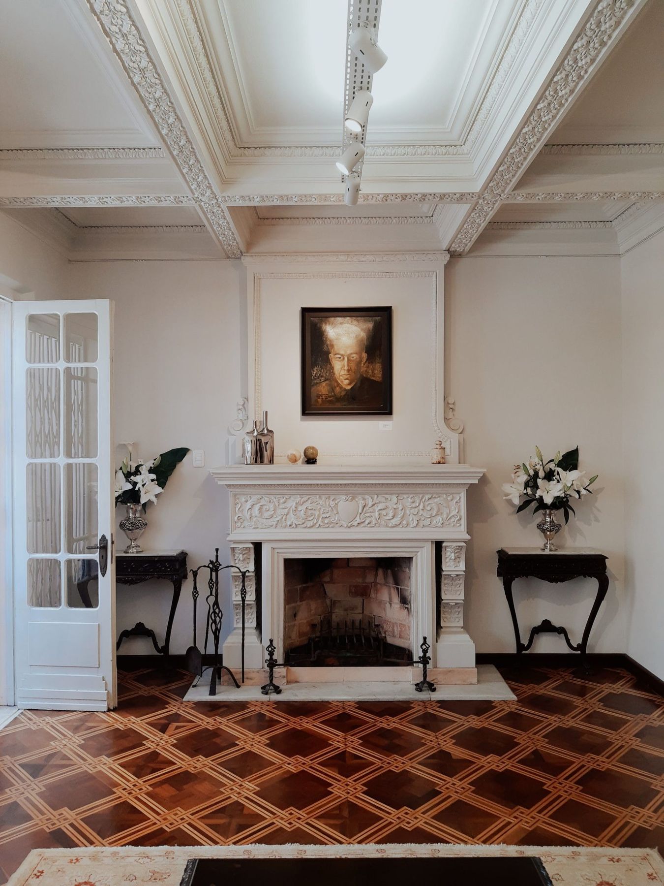 Luxurious room showcasing a classic fireplace, elegant decor, and captivating artwork.