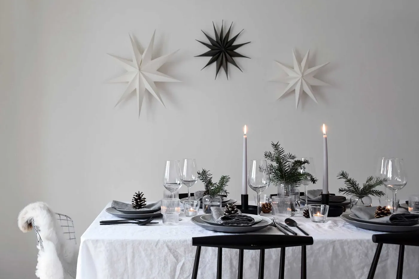 Minimalist Christmas table styling with fir, candles & pine cones |