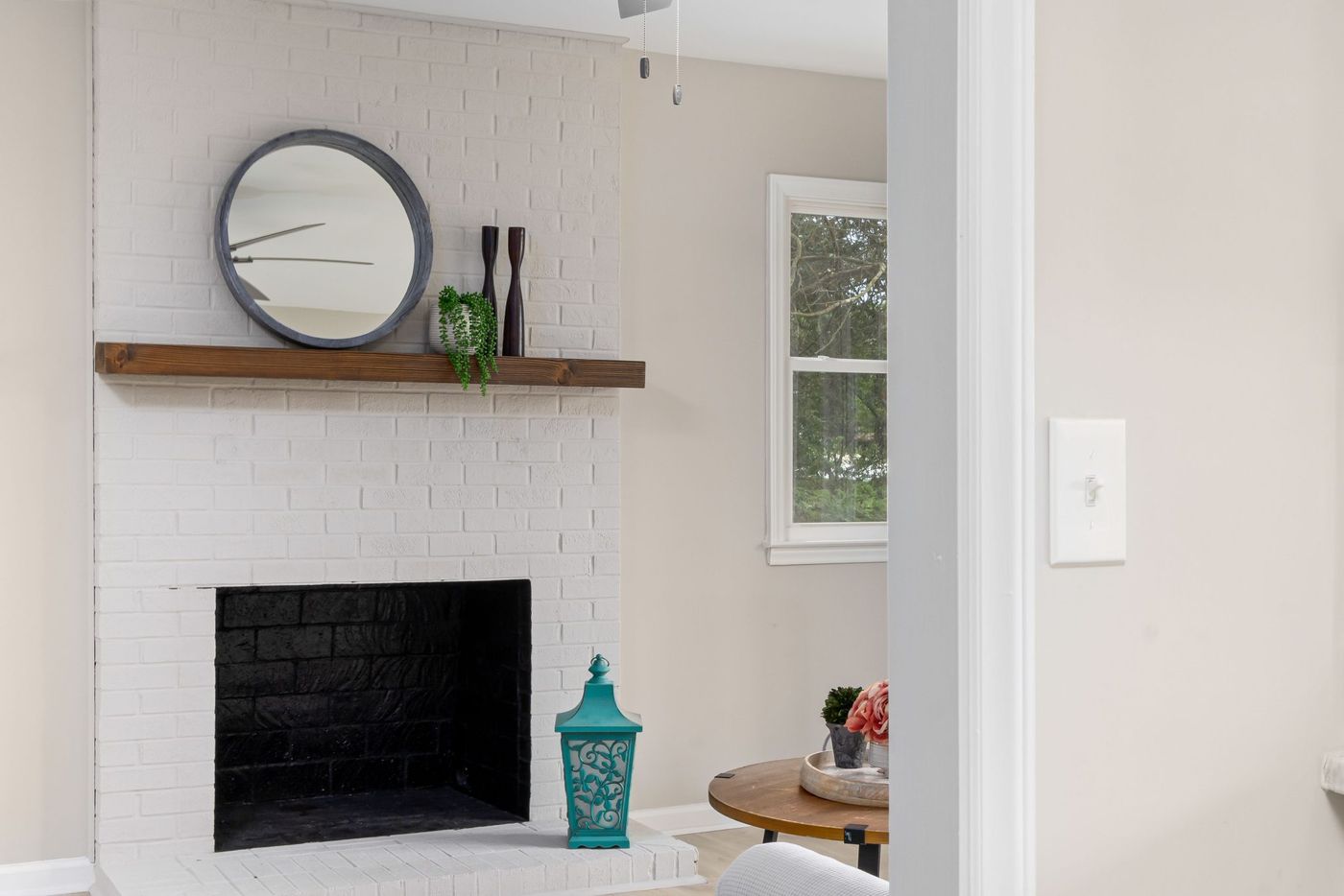 Modern living room with a stylish white brick fireplace and elegant decor elements.