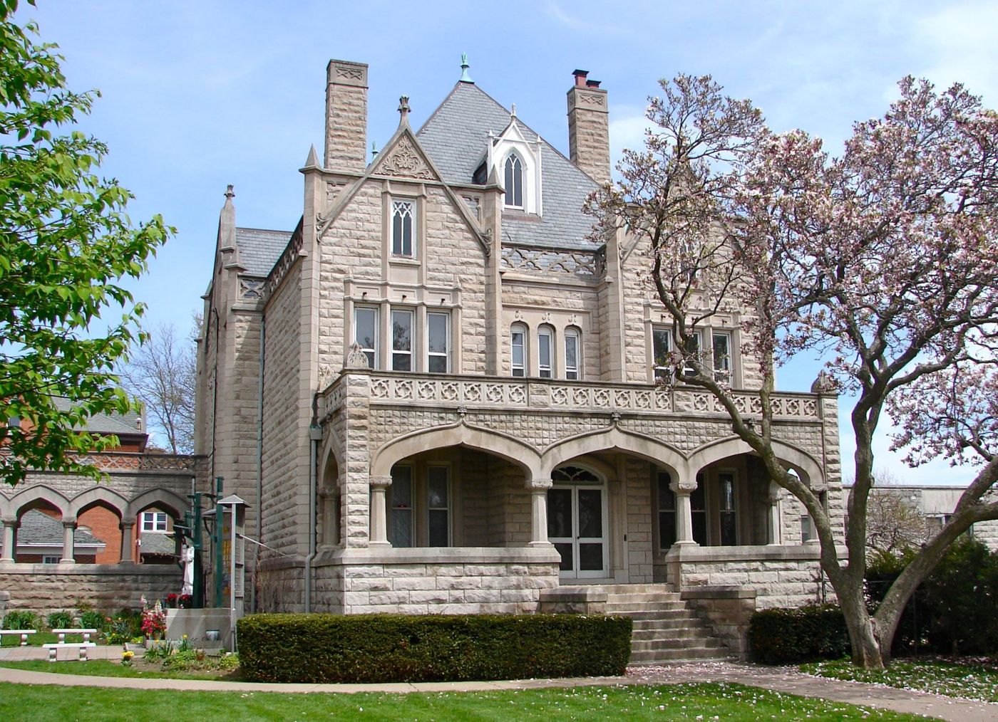 Neo-Gothic Facade: Sandstone Mansion with Ornate Parapet and Pointed Arches