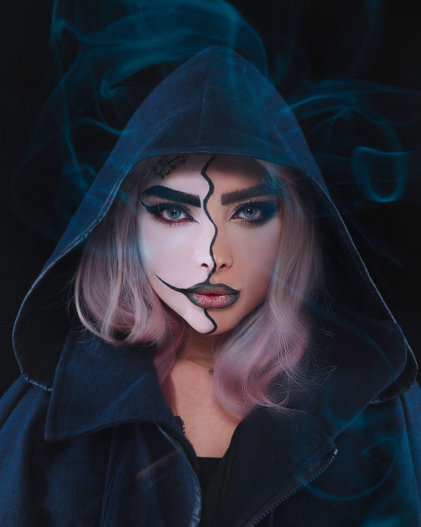 Portrait of a woman with creative makeup and hood. Mysterious and artistic vibe.
