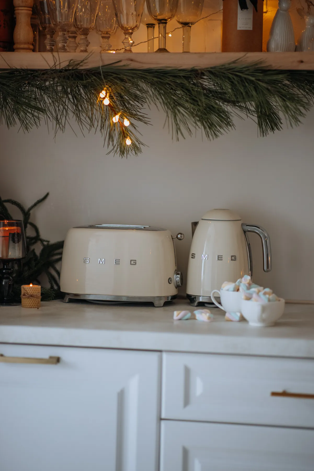 Stylish holiday kitchen with Smeg toaster and kettle under festive decor.