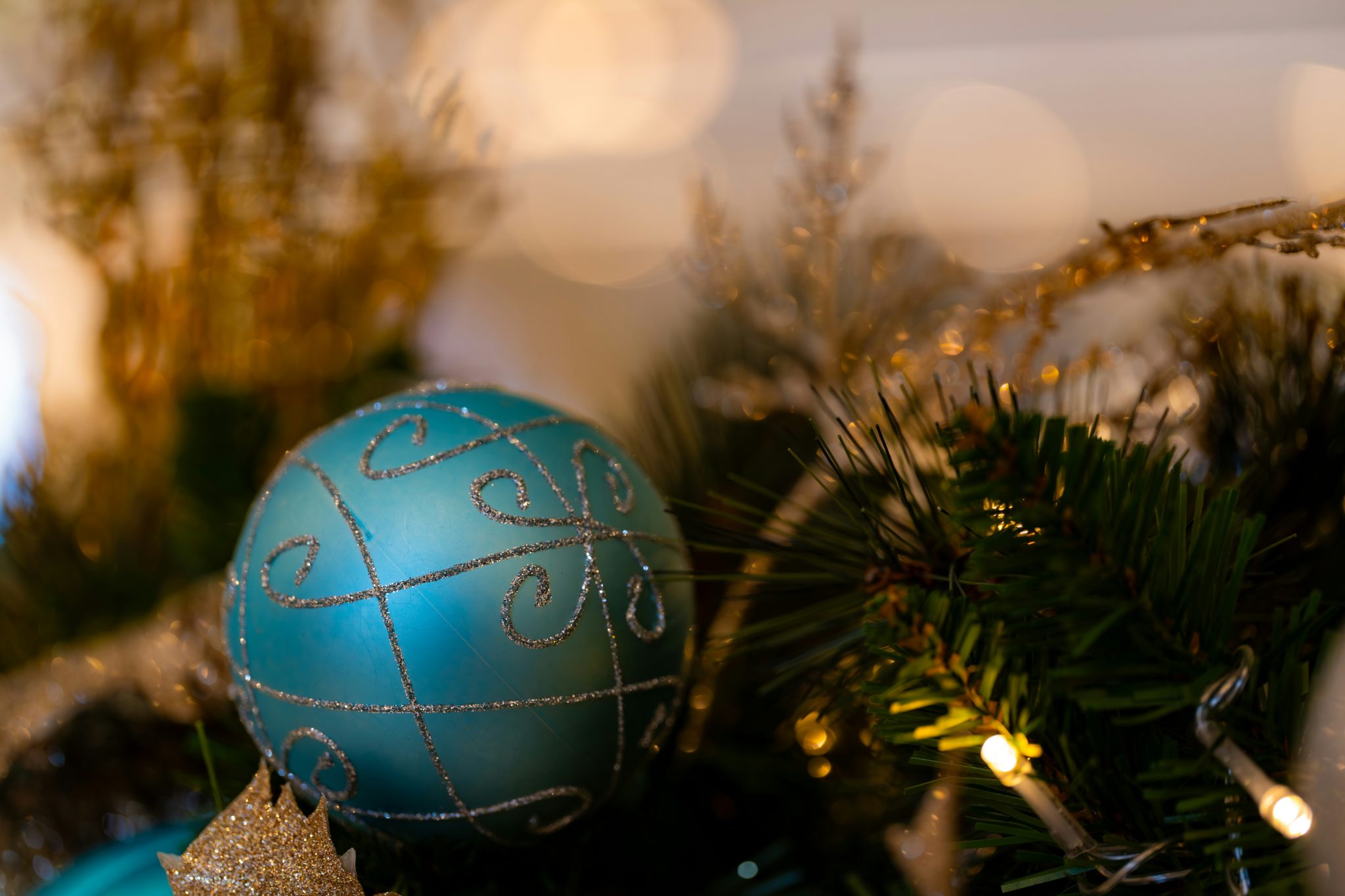 Teal christmas ornament with silver details on tree