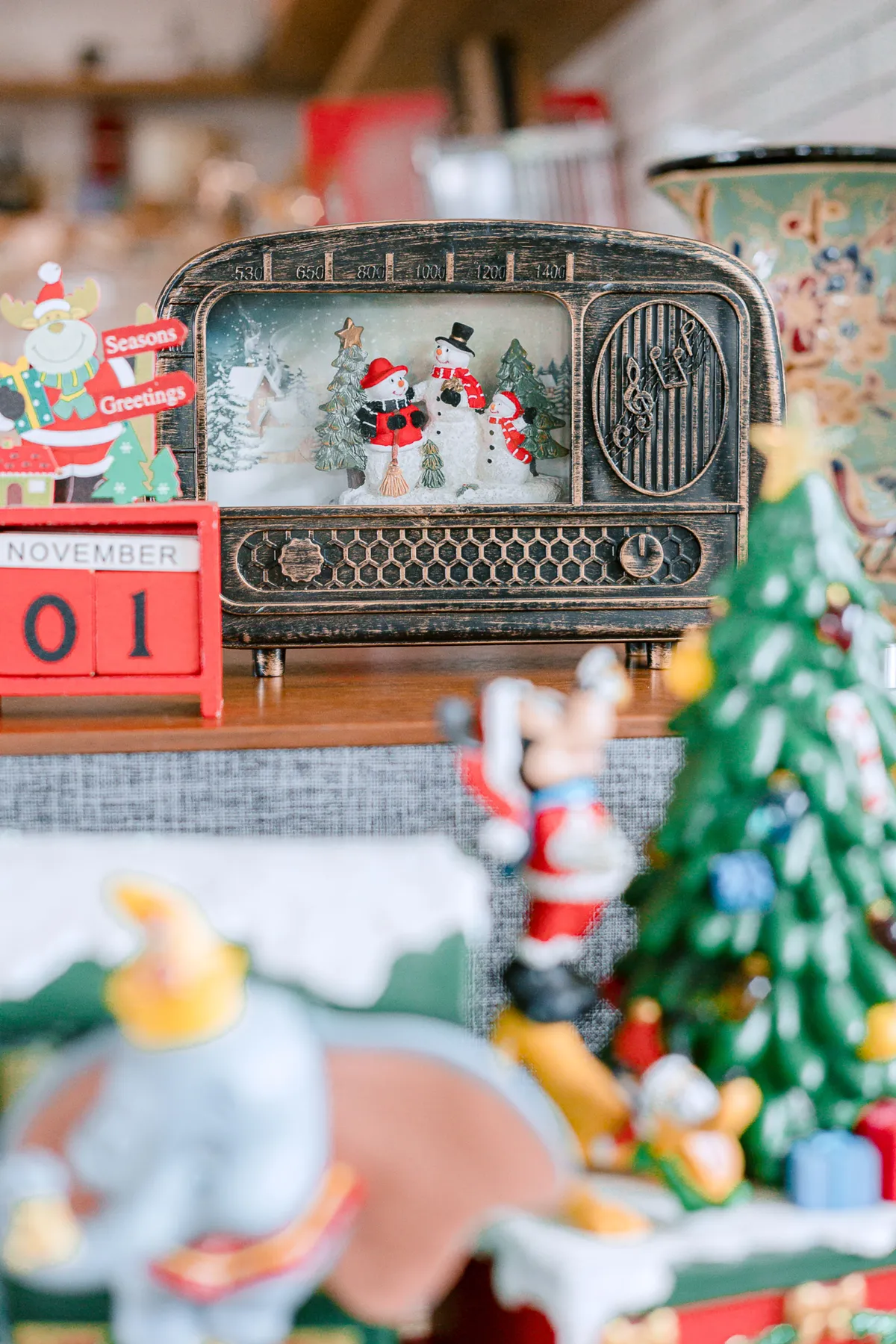 Vintage radio with snowmen figures and Christmas decor, perfect for holiday cheer.