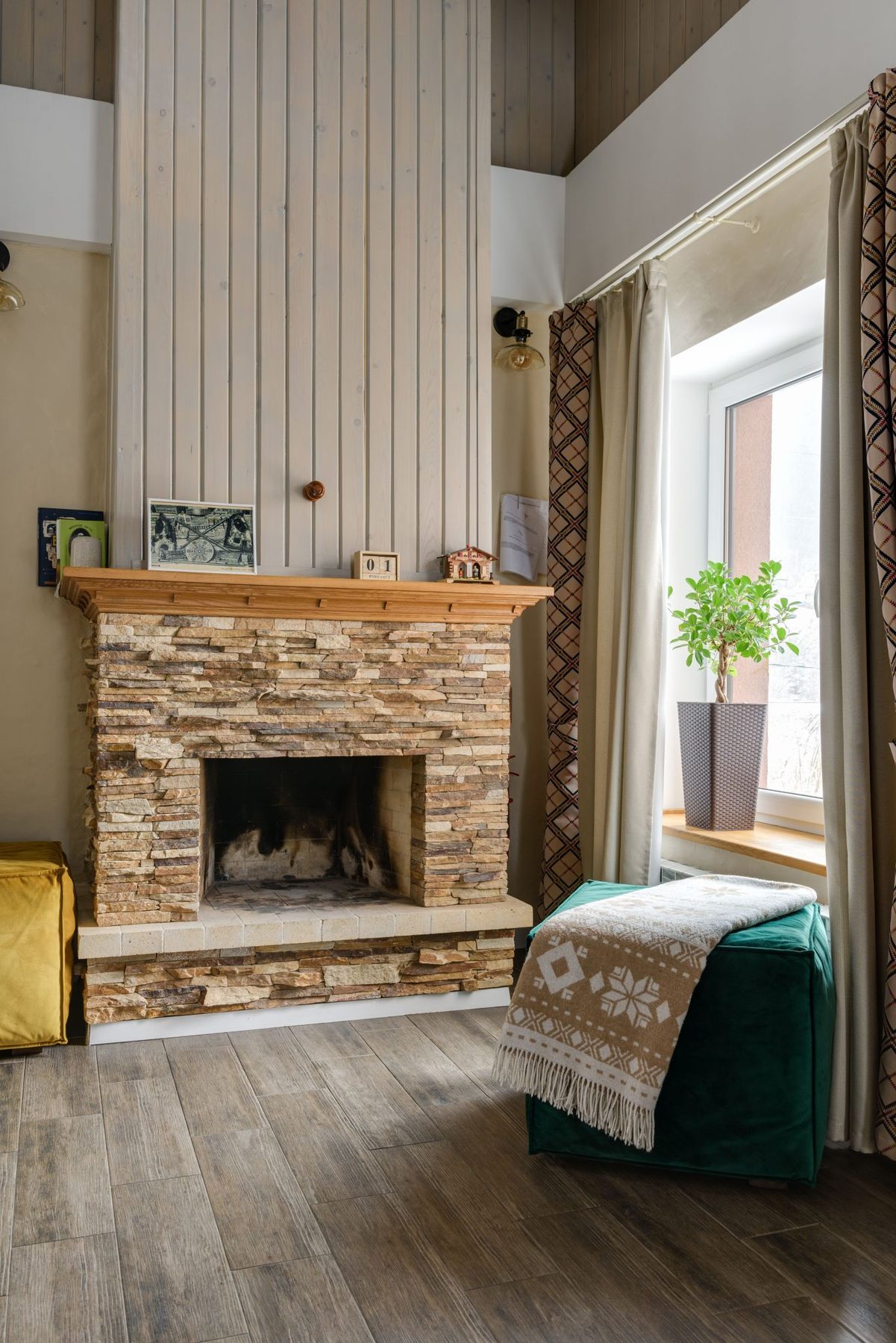 Warm and inviting living room with stone fireplace, wood accents, and natural light.