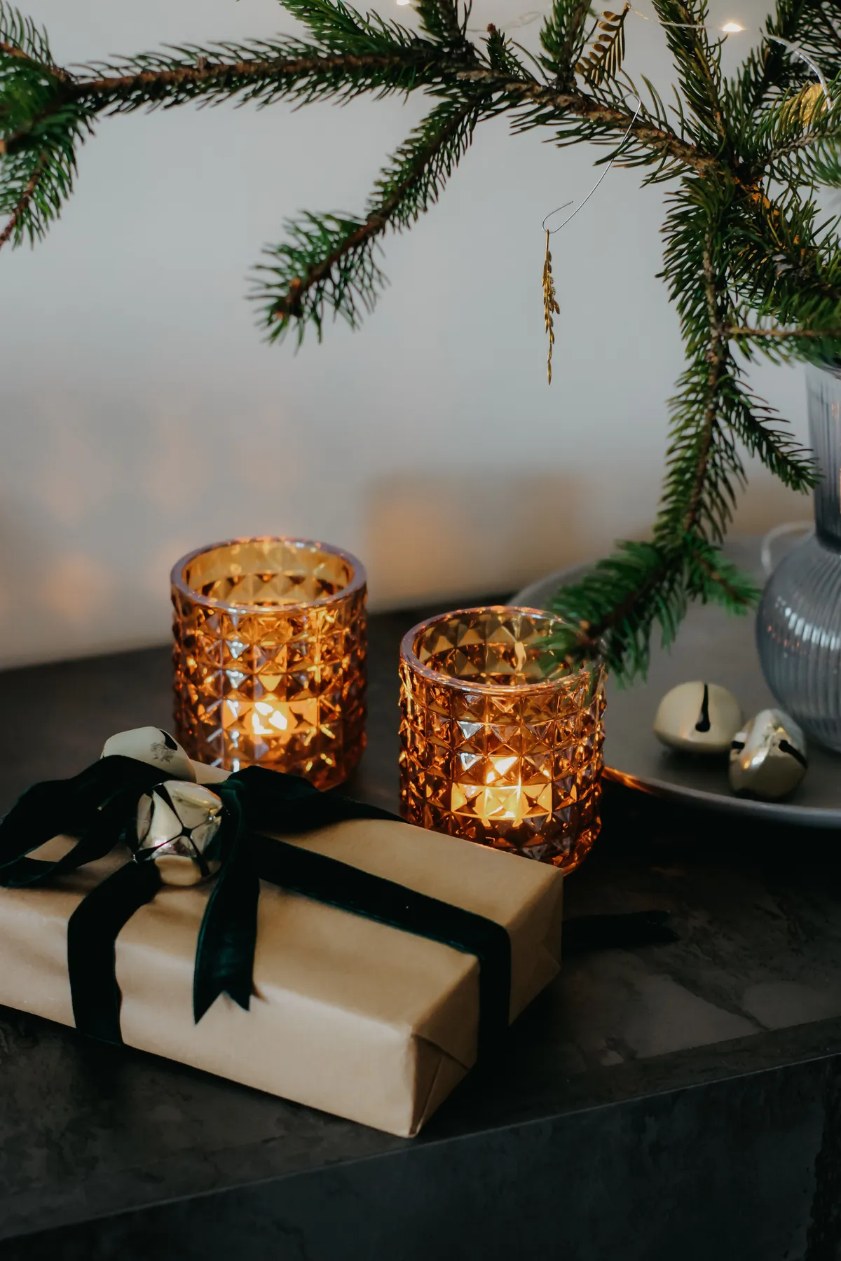 Warm Christmas scene with glowing candles and a wrapped gift, perfect for holiday ambiance.