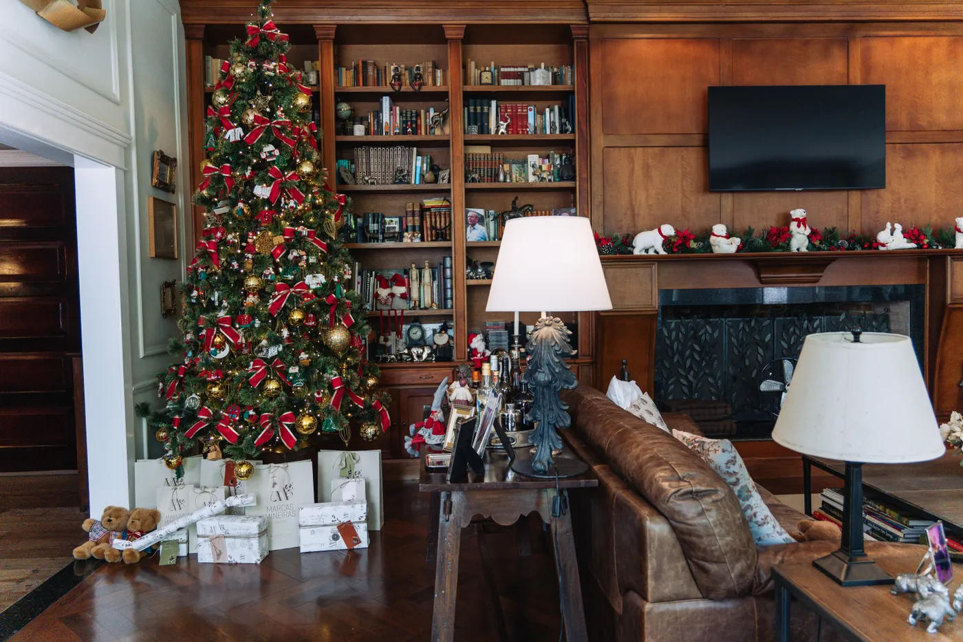 Warm living room scene with a decorated Christmas tree and presents.